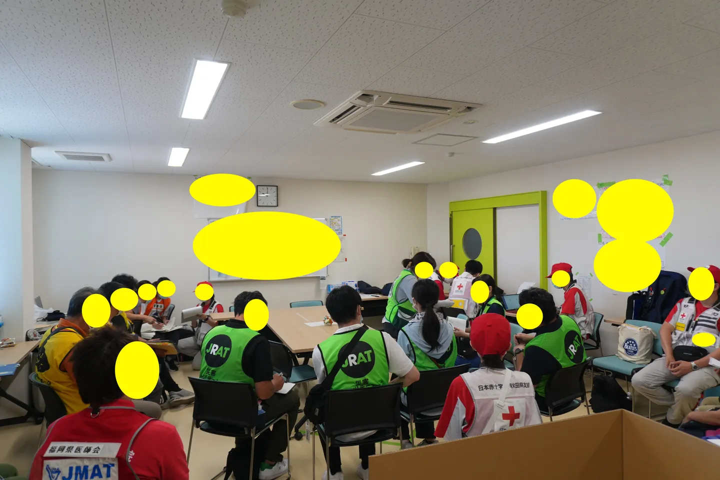 会議室に集まり情報共有する複数の支援チーム