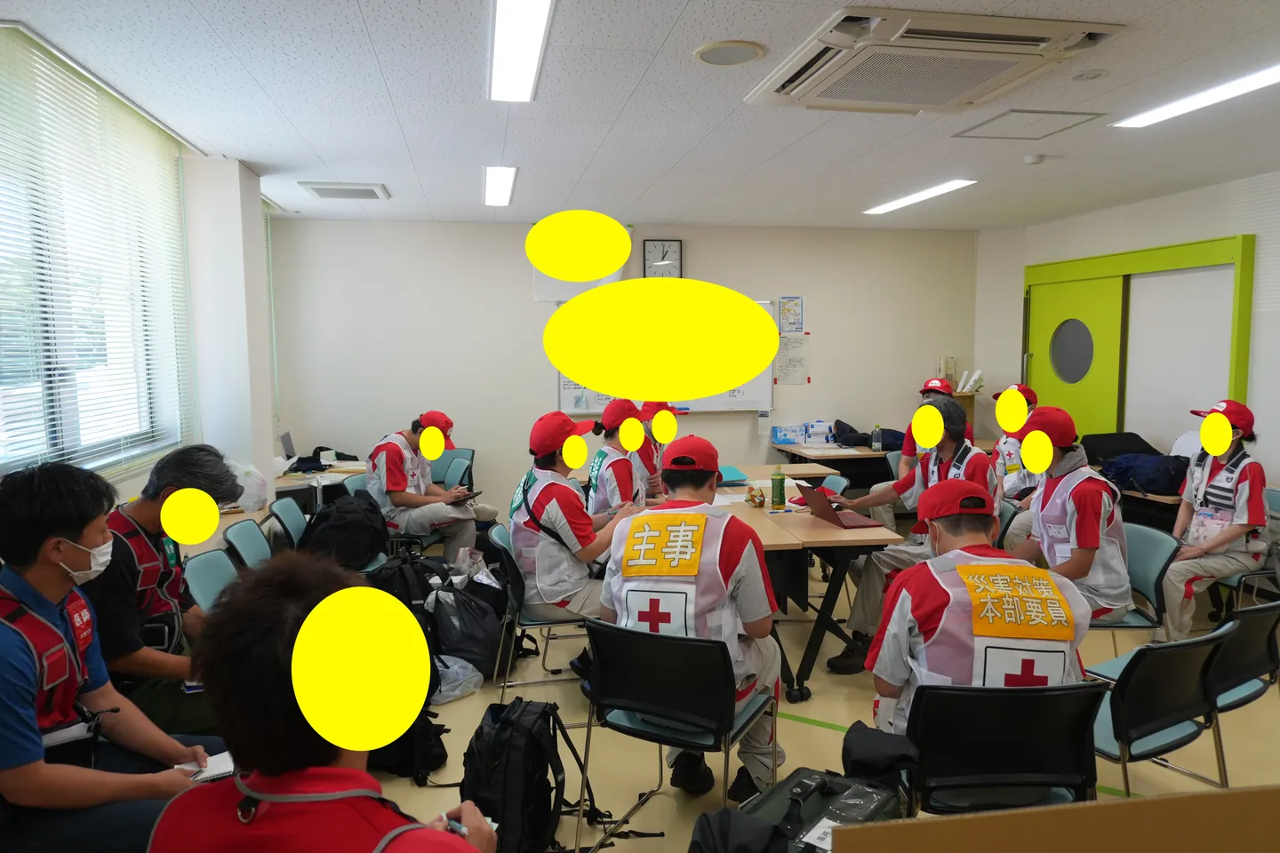机を囲み話し合う多職種の支援者